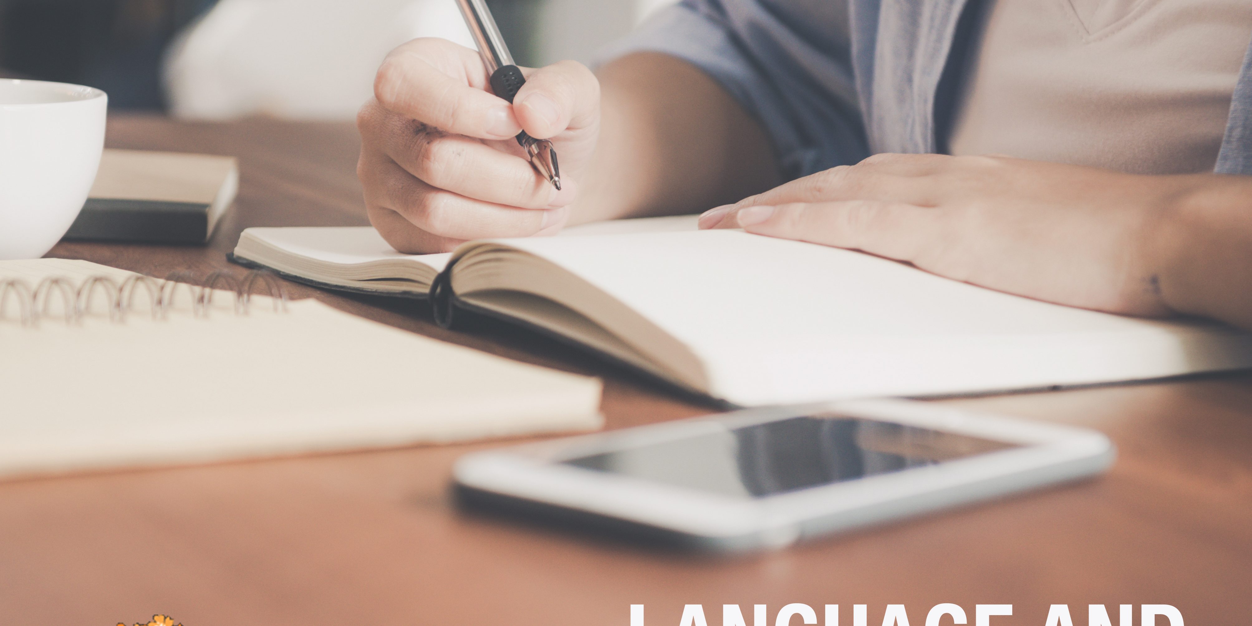Young business woman in white dress sitting at table in cafe and